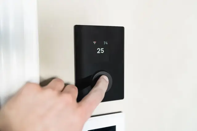 Hand adjusting a wall thermostat